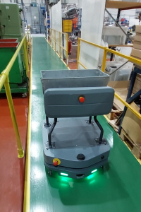 Autonomous mobile vehicle carrying a materials tote through a manufacturing production area